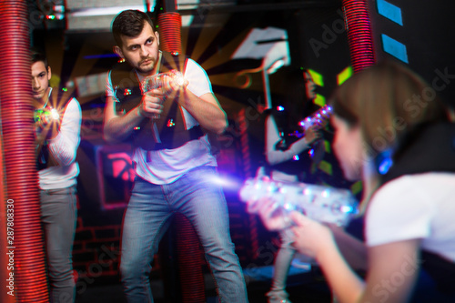 Excited guy laser tag player in bright beams