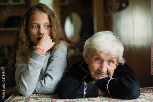 Portrait of an elderly gray-haired woman with her granddaughter.