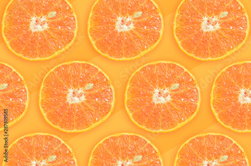 Sliced oranges pattern, fruit with one seed, orange tones on background.