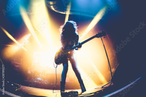 Silhouette of an unrecognizable woman playing the electric guitar