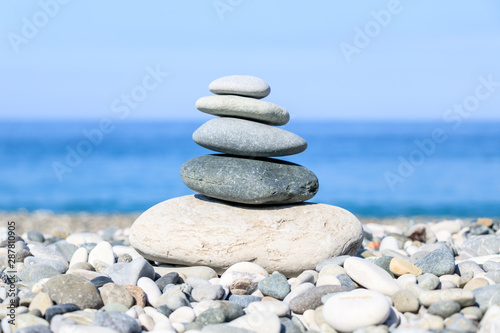 balance of stones on the background of the sea and the beach, the concept of harmony and relaxation, close-up