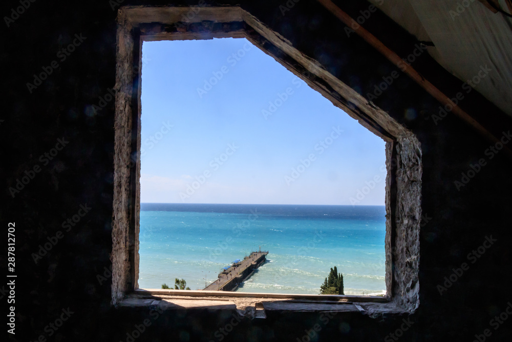 view from the old stone window of the sea and the pier