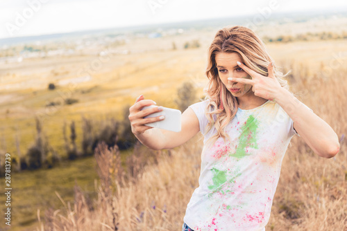 attractive woman in t-shirt taking selfie and showing peace sign