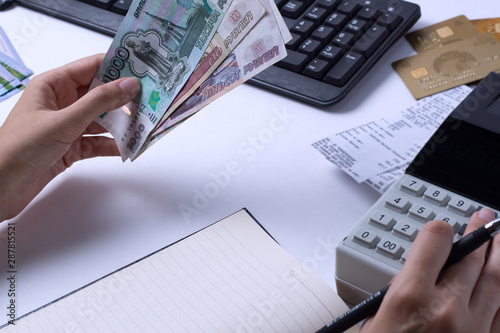 Hands holding Russian rubles at the Desk in the office. Russian Russian cashier Manager at the workplace in a Russian Bank.Issuing salaries, pensions and unemployment benefits in Russia photo