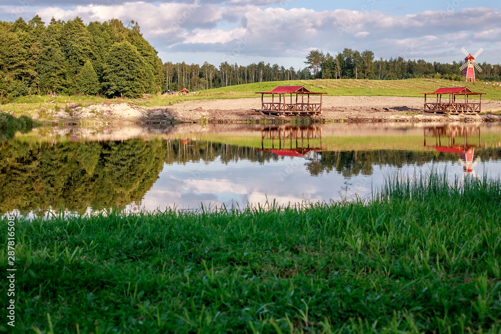 Rest zone. Blue water in a forest lake with pine trees. The forest is reflected in the water.