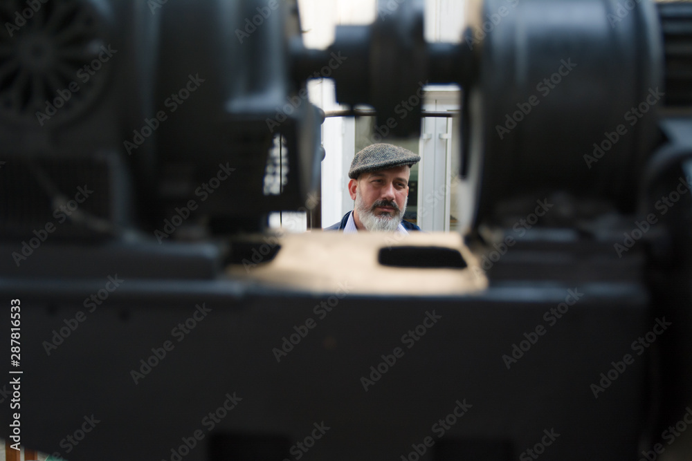Man with beard working on printing press Man with beard working on printing press