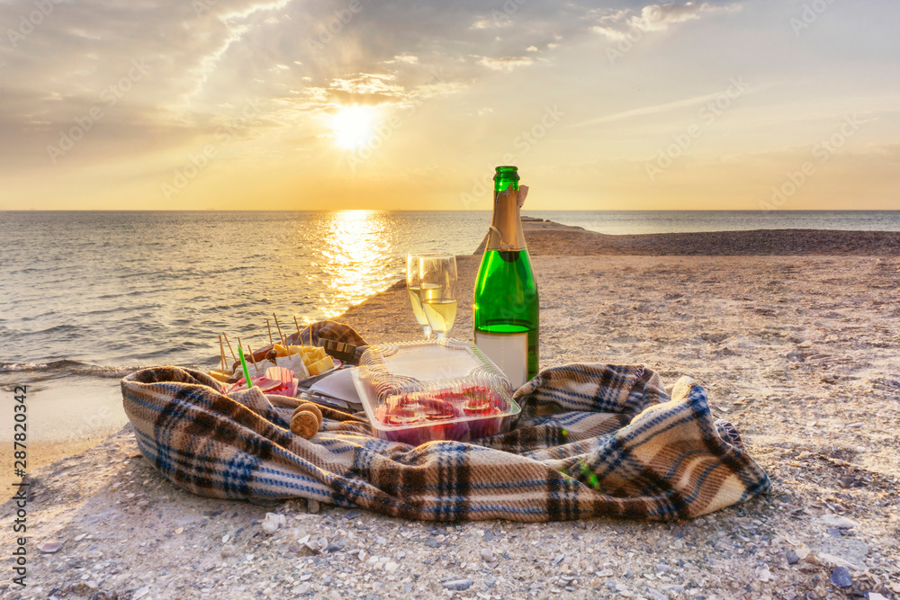 Bottle of champagne and two glasses at sunrise Bottle of champagne and two glasses at sunrise