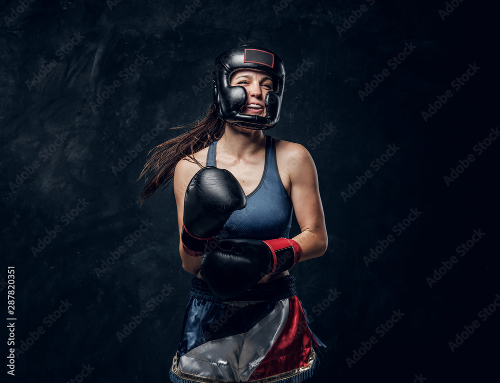 Portrait of cheerful boxer in protective helmet and gloves ready to fight.