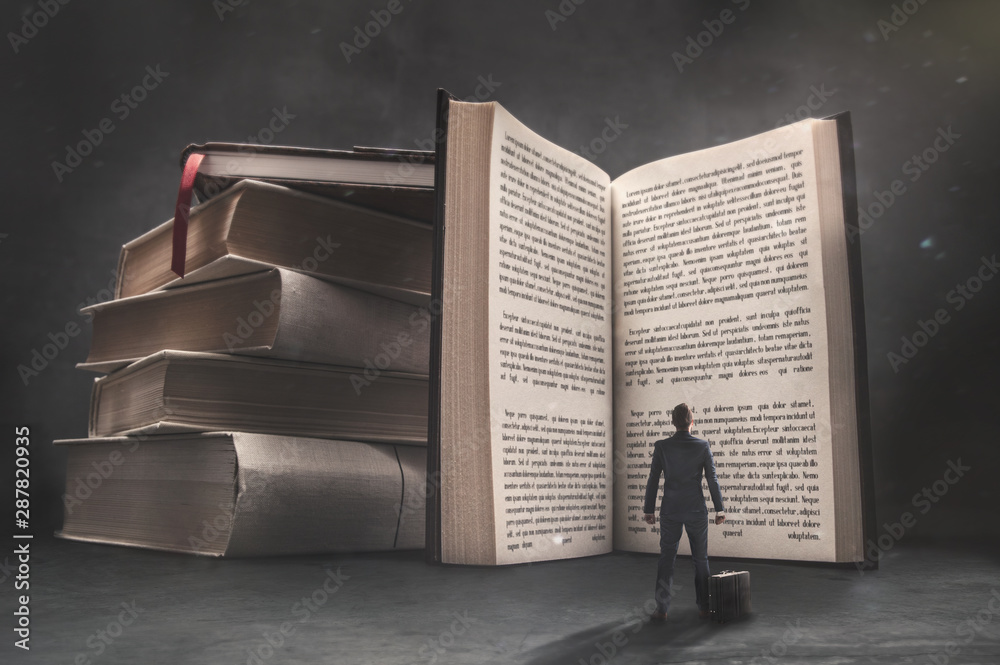 Surrealistic image of businessman looking at big open book in dark room. - obrazy, fototapety, plakaty 