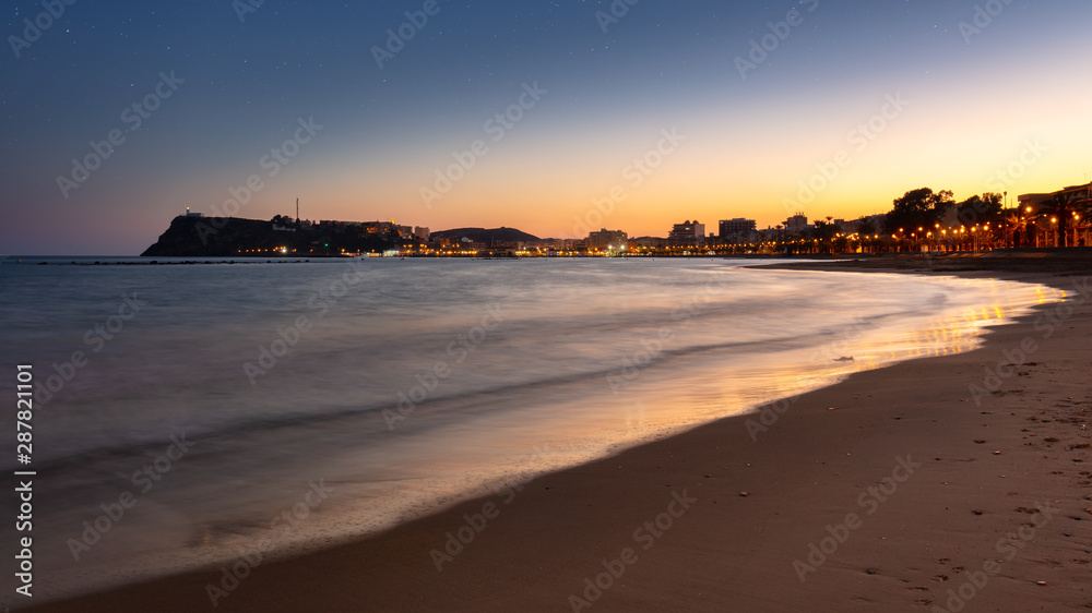 Panoramic view over the bay of the spanish town Mazarron at the mediterranean sea after sunset. Warm orange light and the lighthouse high on the cliffs. Panoramic view over the bay of the spanish town Mazarron at the mediterranean sea after sunset. Warm orange light and the lighthouse high on the cliffs.