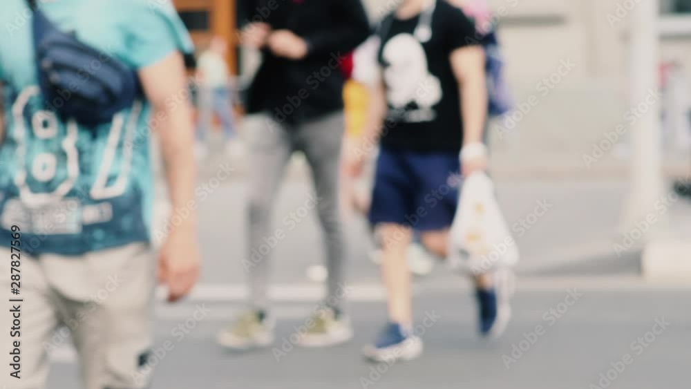 Defocused people cross the road at a pedestrian crossing Defocused people cross the road at a pedestrian crossing