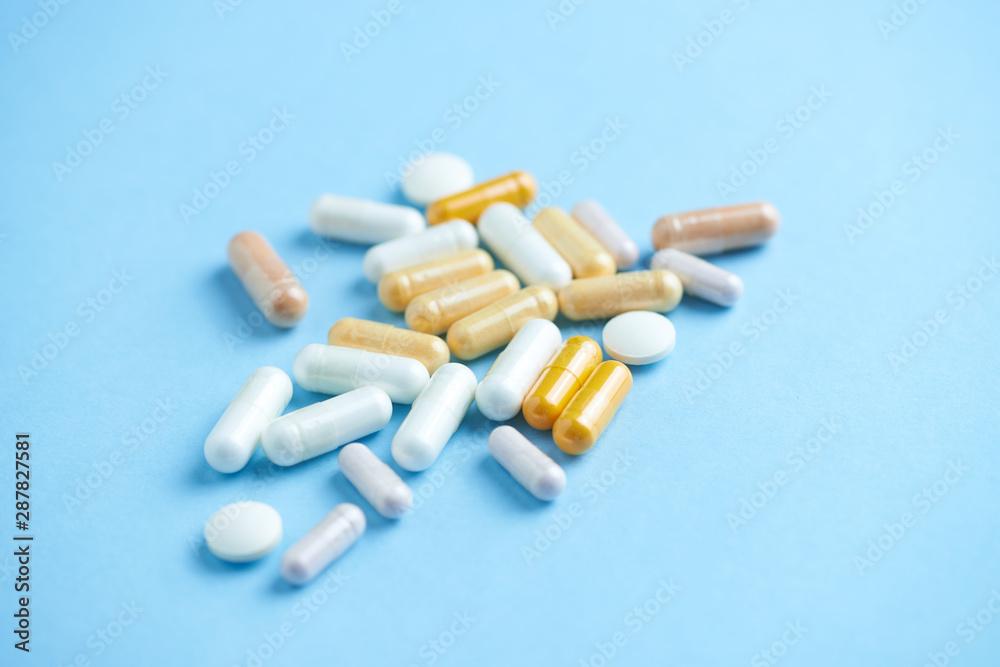 Vitamins and supplements on bright paper background. Concept for a healthy dietary supplementation. Close up. Copy space. Vitamins and supplements on bright paper background. Concept for a healthy dietary supplementation. Close up. Copy space.