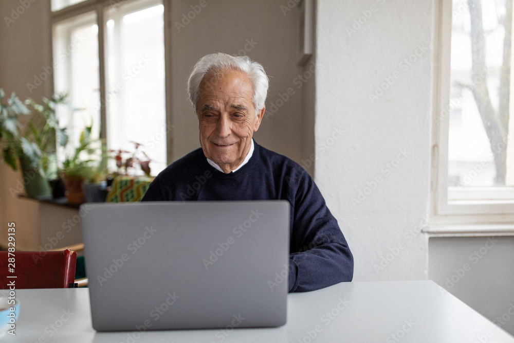 Senior man using laptop on table at home Senior man using laptop on table at home