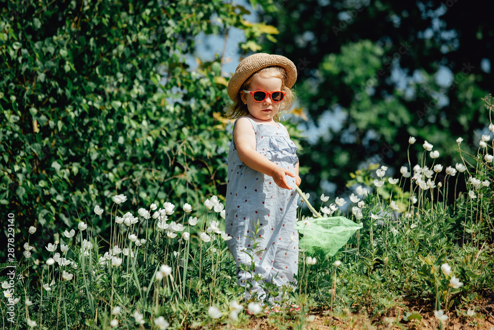 Adorable little girl catching butterflies and bugs with her scoop-net. Adorable little girl catching butterflies and bugs with her scoop-net.