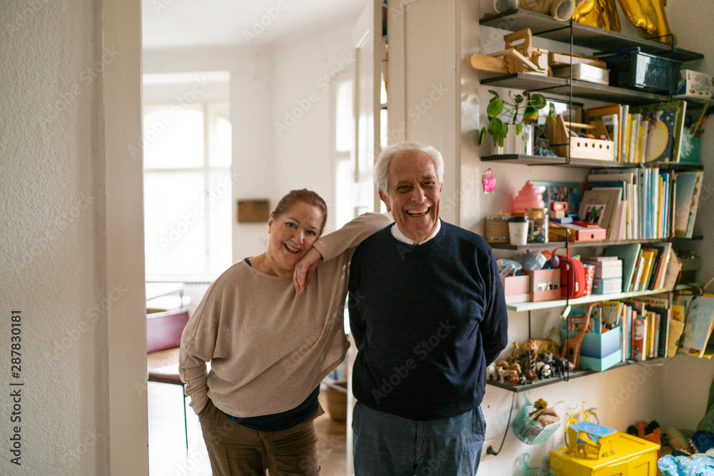 Portrait of happy senior couple standing in children's room Portrait of happy senior couple standing in children's room