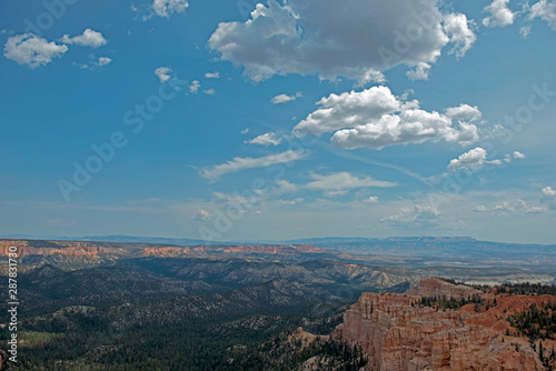 Wide view over Bryce Canyon with clouds and hoodoos on the right side