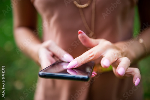 Beautiful slim lady is using her smartphone