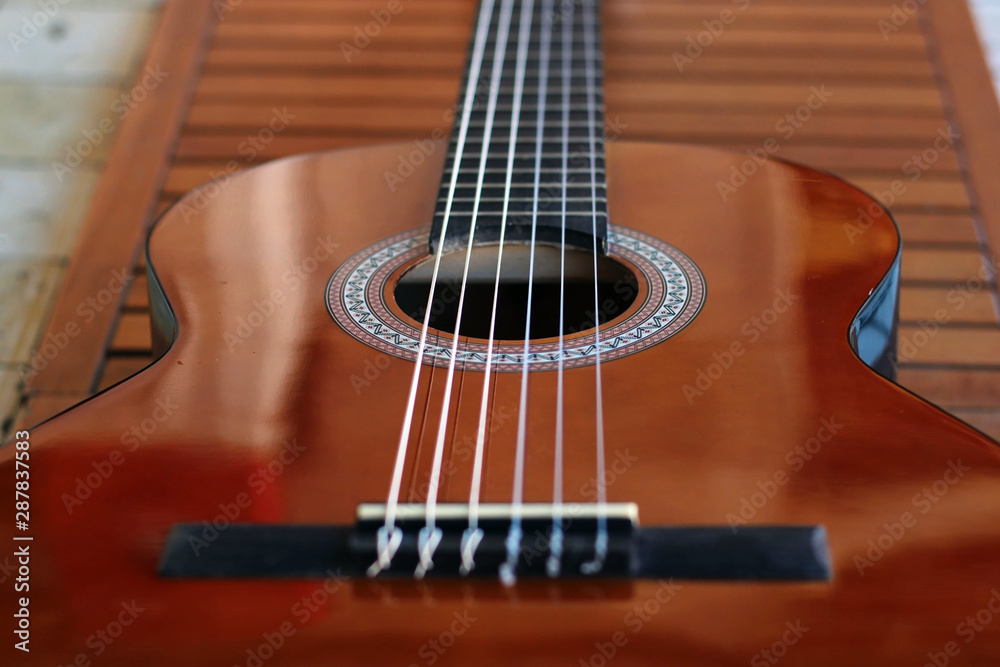 Music Concept: Brown acoustic guitar on a wooden background.