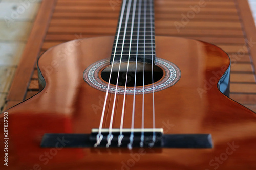 Music Concept: Brown acoustic guitar on a wooden background.