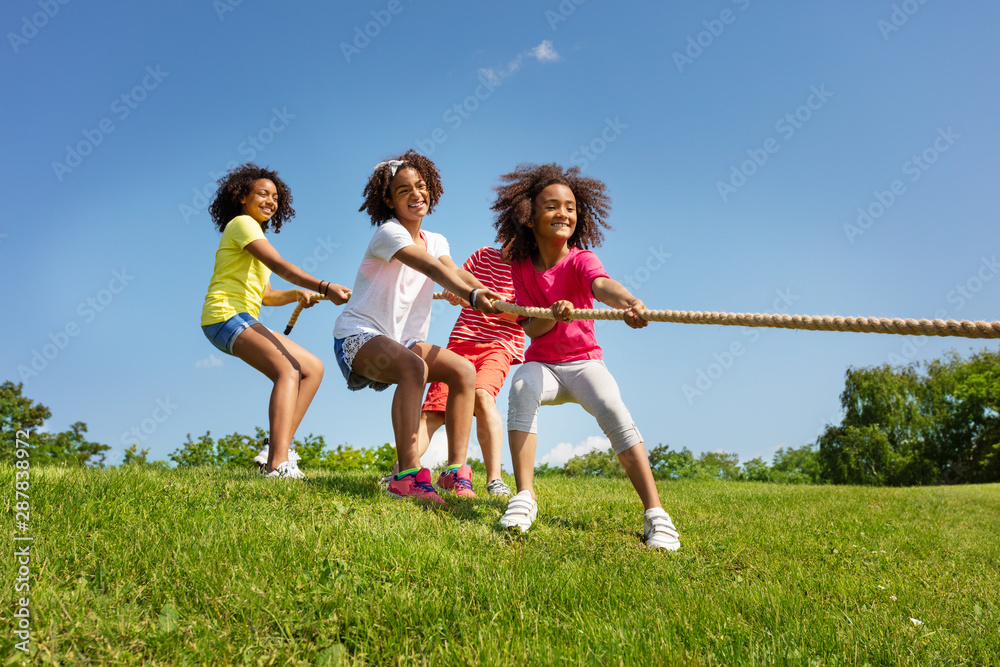 Group of boys and girls play pulling cord game Group of boys and girls play pulling cord game