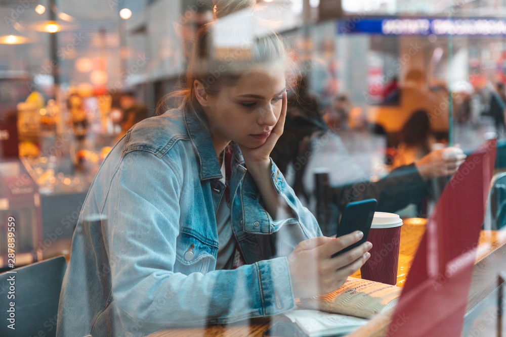 Young woman in a cafe using a smartphone Young woman in a cafe using a smartphone