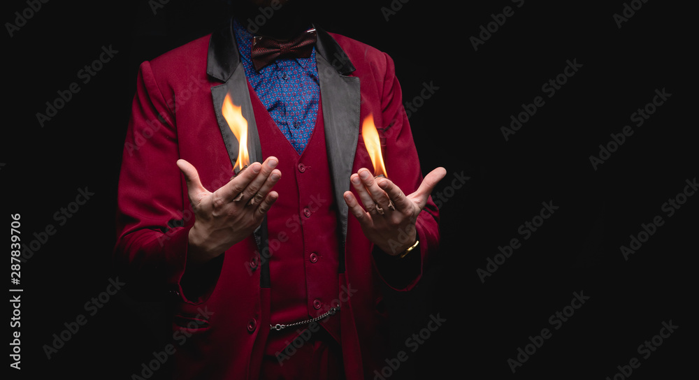 Magician shows trick with fire burn from palms hands