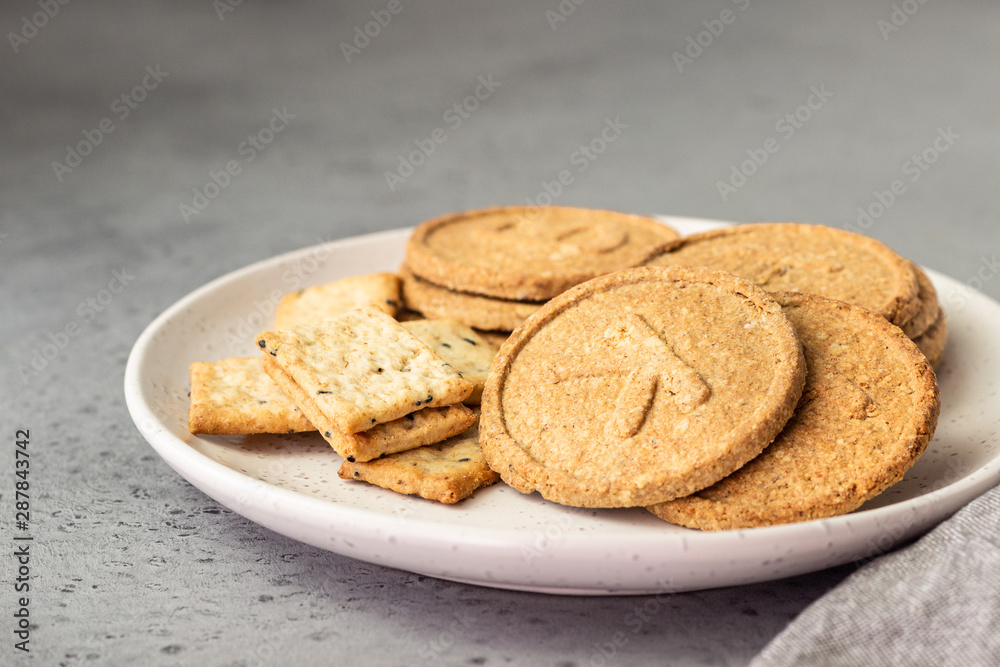 Thin crispy wholegrain crackers with seeds on grey concrete background. Thin crispy wholegrain crackers with seeds on grey concrete background.