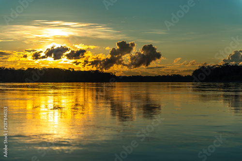 Sunset along the Pastaza river in the Amazon Rainforest with a unsharp foreground, Ecuador. photo