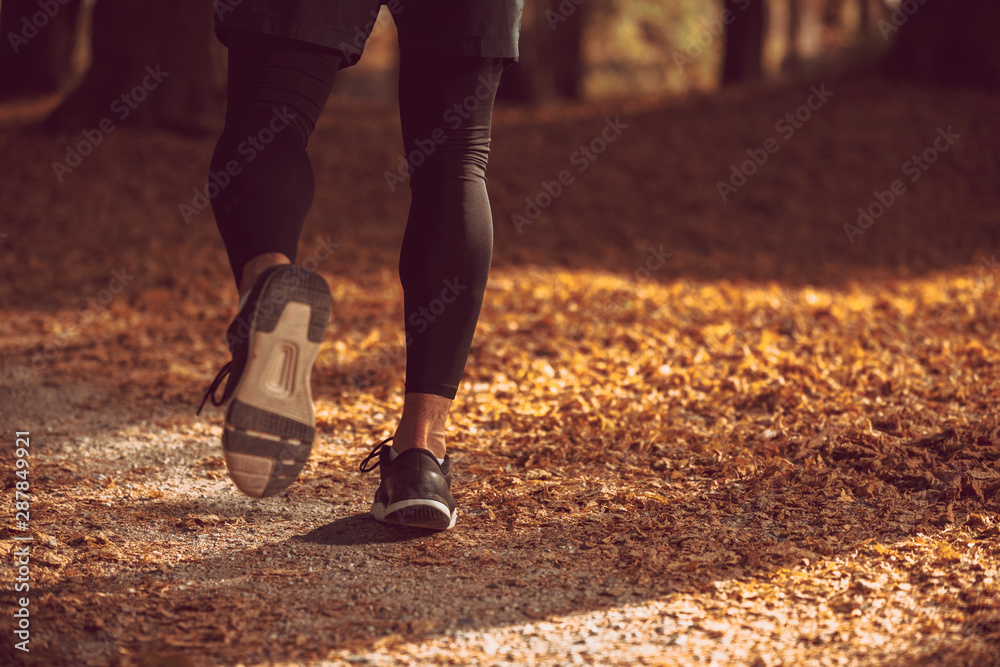 Man running in a park, legs detail.