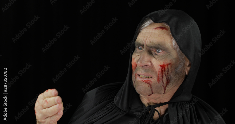 Old executioner Halloween makeup and costume. Elderly man with blood on his face Old executioner Halloween makeup and costume. Elderly man with blood on his face