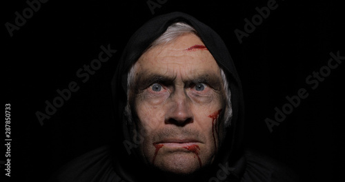 Old executioner Halloween makeup and costume. Elderly man with blood on his face