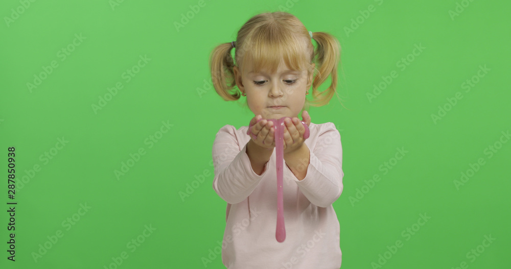 Kid playing with hand made toy slime. Child having fun making pink slime Kid playing with hand made toy slime. Child having fun making pink slime