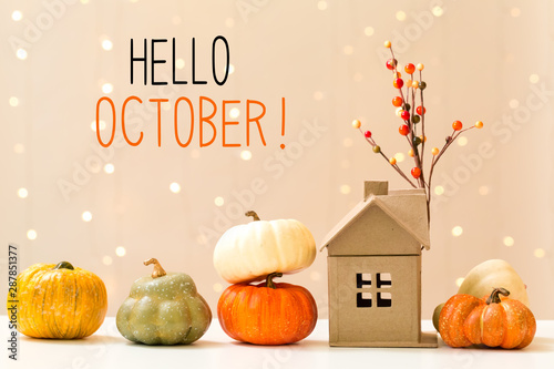 Hello October message with collection of autumn pumpkins with a toy house photo