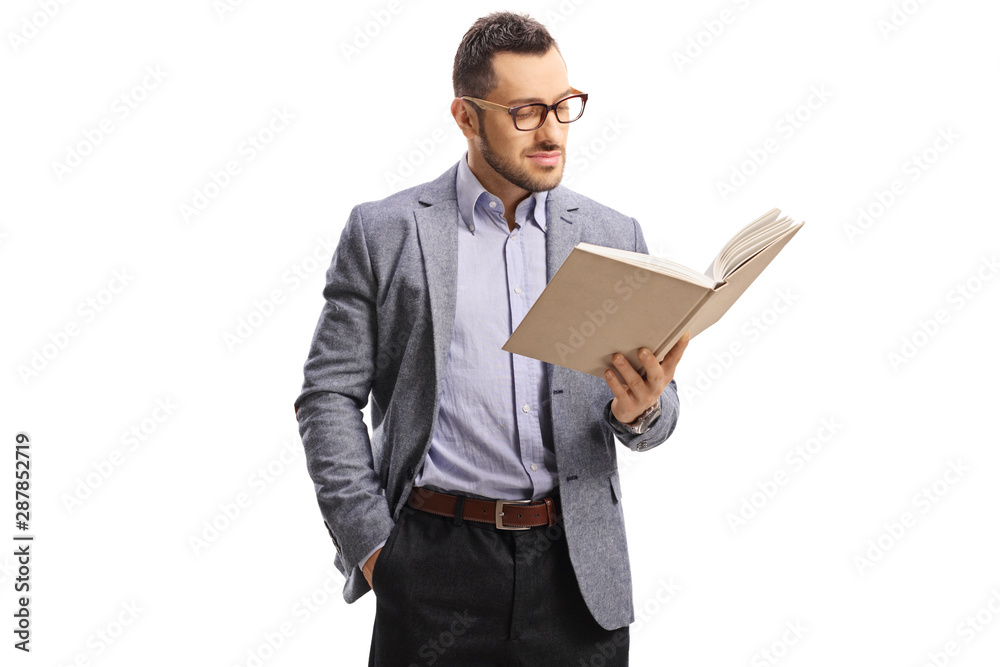 Young man with glasses standing and reading a book