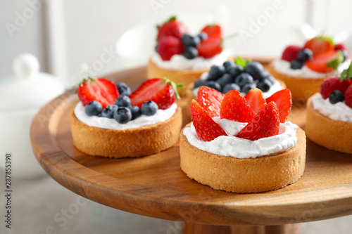Cake stand with different berry tarts on table Fototapet