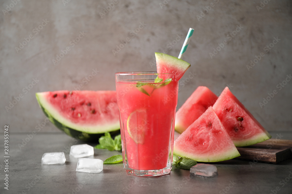 Glass of tasty refreshing drink with watermelon on grey table Glass of tasty refreshing drink with watermelon on grey table