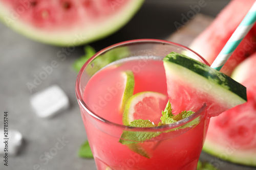 Glass of tasty refreshing drink with watermelon on grey table, closeup