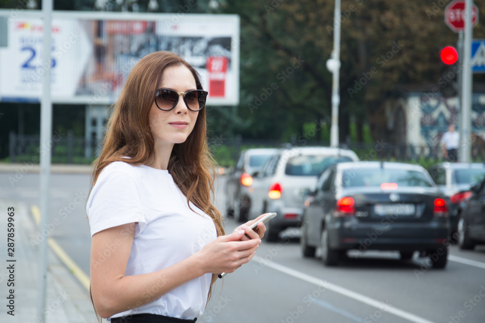 Cheerful attractive young woman with red backpack and book walking in the city Cheerful attractive young woman with red backpack and book walking in the city