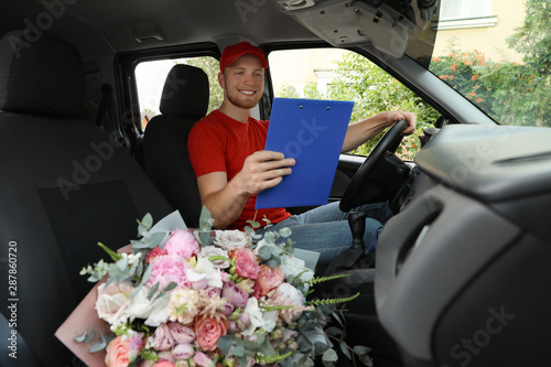 Delivery man with beautiful flower bouquet in car