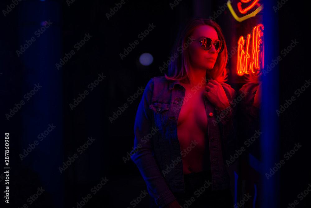 Sexy portrait of a young girl in sunglasses and with in the night city,  with creative