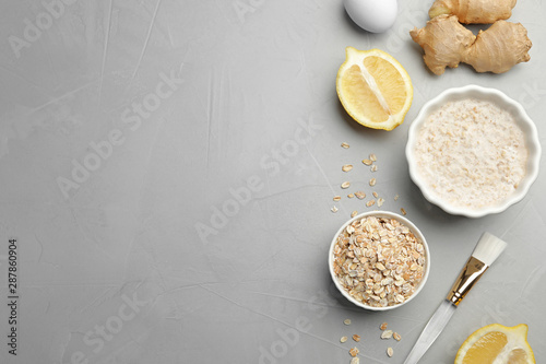 Different ingredients and handmade face mask on grey stone background, flat lay. Space for text