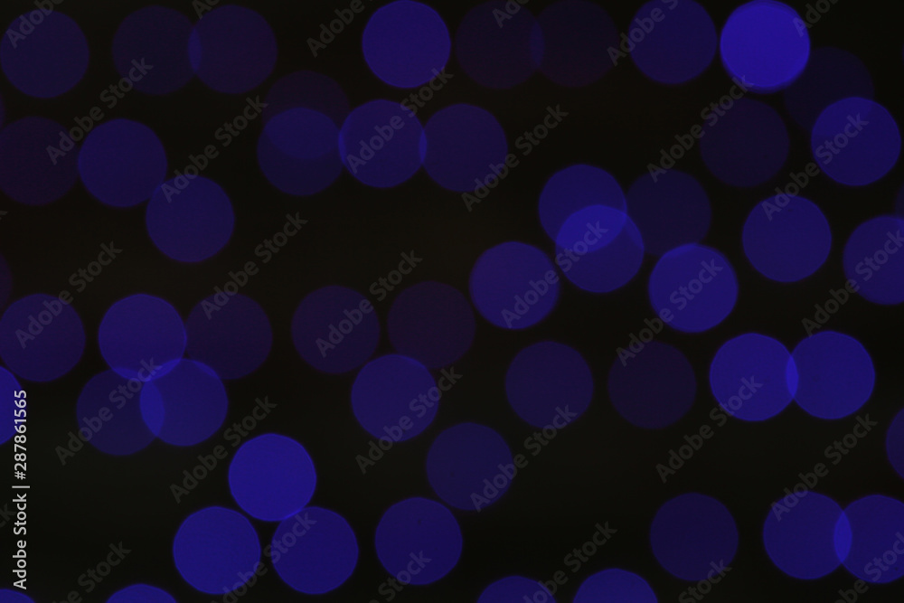 Blurred view of blue Christmas lights on dark background Blurred view of blue Christmas lights on dark background