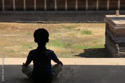 Indian young boy meditating at hindu temple photo
