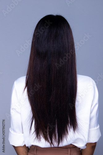 Back side view of Women to show long straight black Hair style before after applying hair styling, studio lighting gray background isolated, copy space for text logo