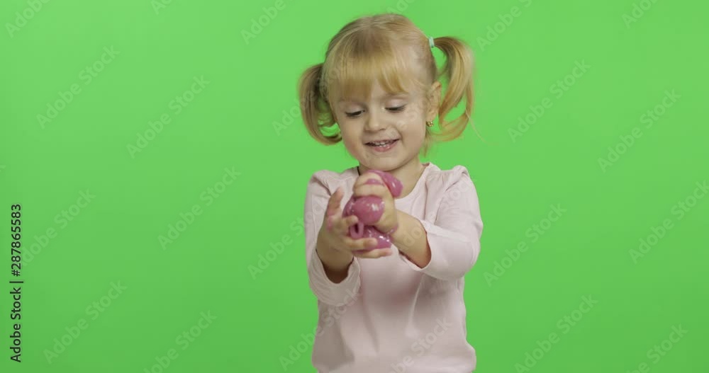 Kid playing with hand made toy slime. Child having fun making pink slime Kid playing with hand made toy slime. Child having fun making pink slime
