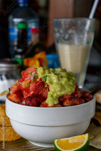 Chifrijos, con jugo de cas al fondo, como platillo típico de Costa Rica, servidos en un restaurante costarricense