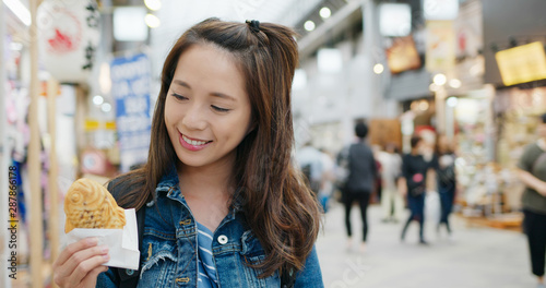 Photography Travel woman eating Taiyaki on the street on Tokyo city
