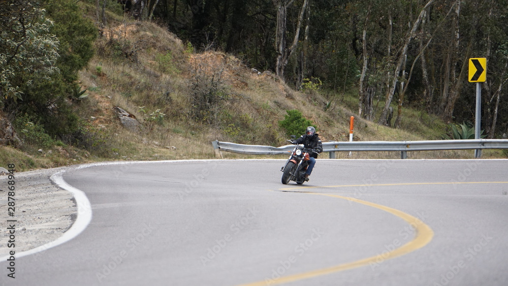 Motociclista tomando curva en carretera