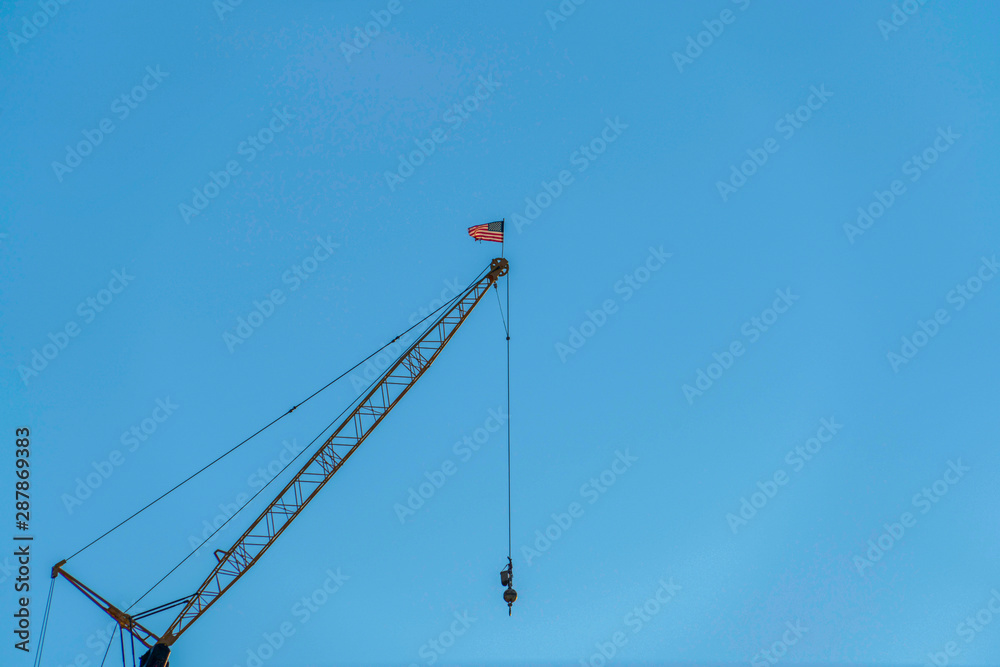 Metal construction crane viewed from below against cloudless blue sky Metal construction crane viewed from below against cloudless blue sky