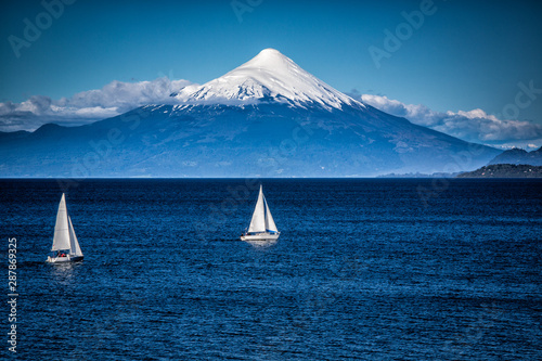 Two sailboats sail in front of snow capped Orsono Volcano in Chile.jpg